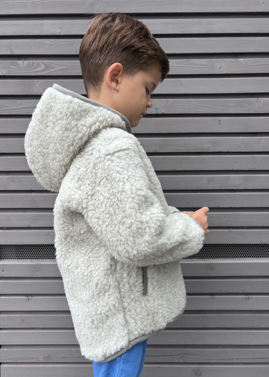Junge trägt einen Teddy-Hoodie aus Merinowolle